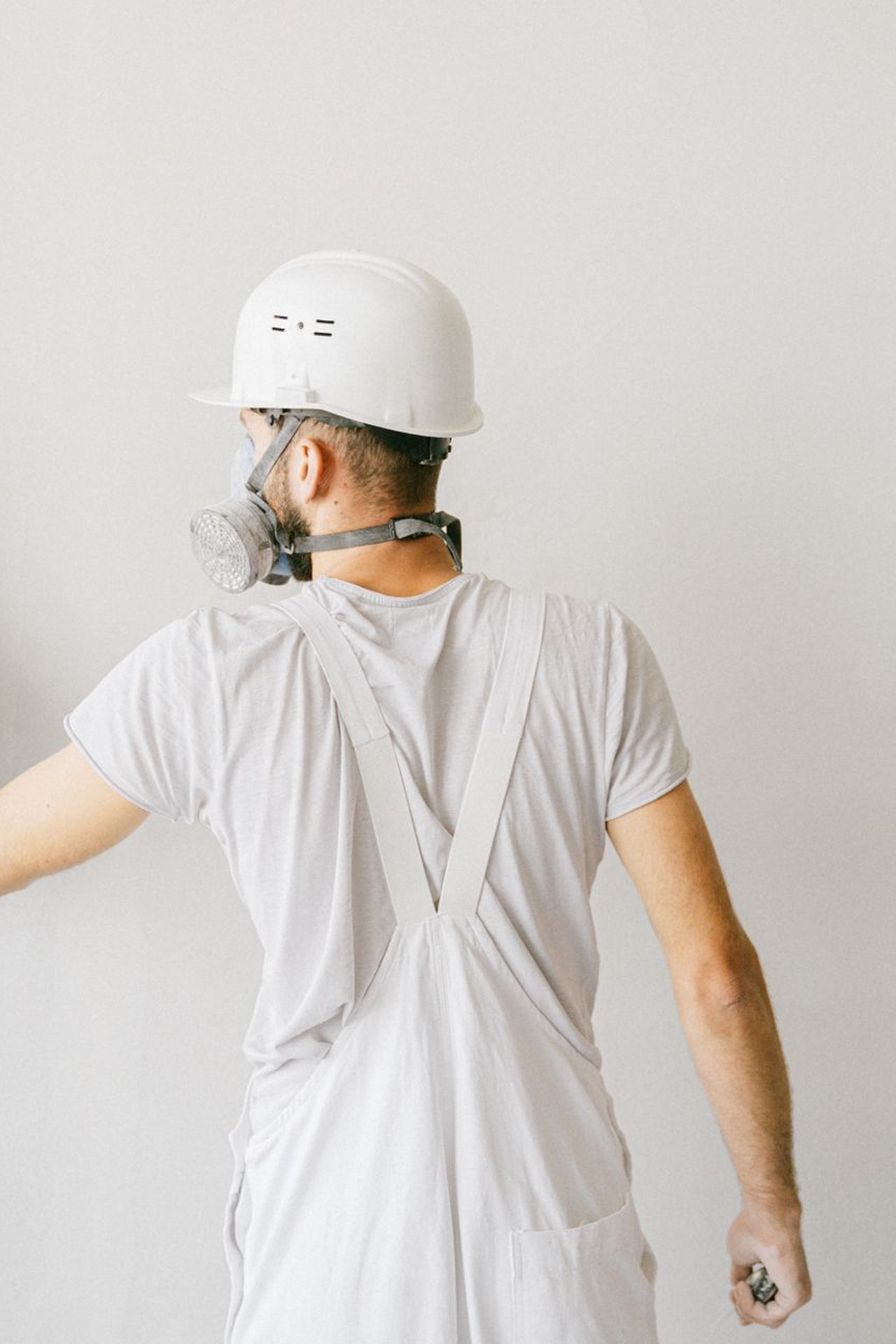 Professional in plain workwear finishing a residential wall with a trowel — illustrative image