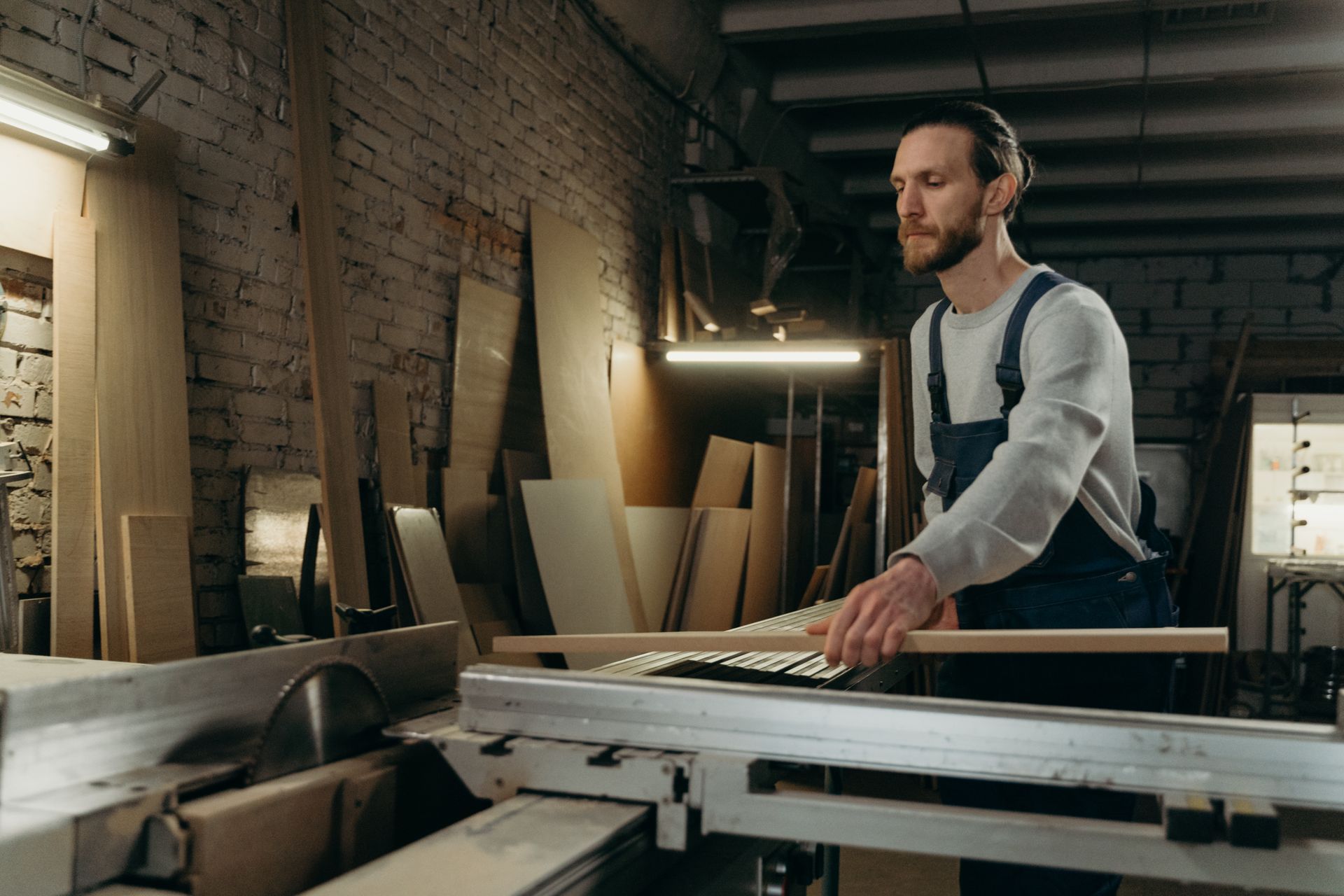 Carpenter working with a table saw in a wood workshop — illustrative image